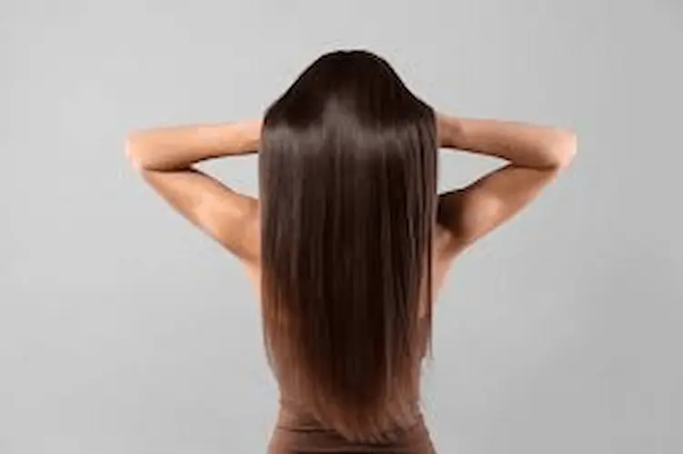 Mujer tocando su cabello liso, suave y brillante